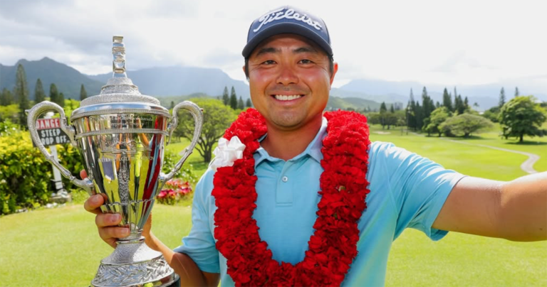 Mid-Pacific Open 2026 Winner John Oda holding trophy on the course with a thick red lei